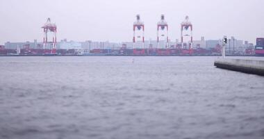 Miniature industrial cranes near the container wharf in Tokyo cloudy day video