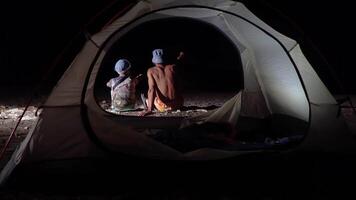 Son and father near the tent at night. Freedom and travel concept. video