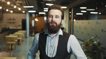 Close up portrait of a successful businessman with a beard of Caucasian appearance. The man folds his arms and looks intently at the camera. The look of a confident businessman leader. photo