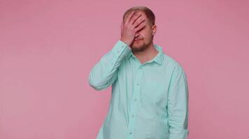 Upset tourist stylish man making face palm gesture, feeling bored, disappointed in result, bad news video