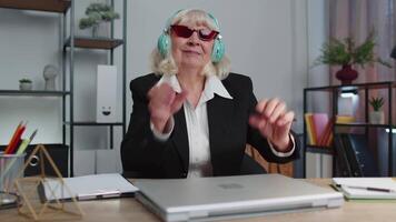 Happy senior business woman dancing victory dance celebrating weekend holiday success win in office video
