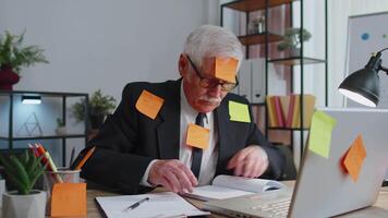 Tired exhausted senior business man office manager with laptop sticky notes sticks with many tasks video