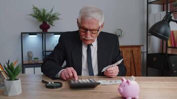 senior bedrijf kantoor Mens accountant of bankier gebruik makend van rekenmachine maken geld contant geld berekeningen video