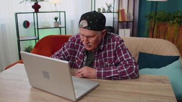 Amazed senior grandfather use laptop computer, receive good news message, shocked by sudden win, wow video