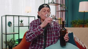 sonriente mayor abuelo hombre Bebiendo rojo vino vaso celebrando cumpleaños aniversario lotería ganar video