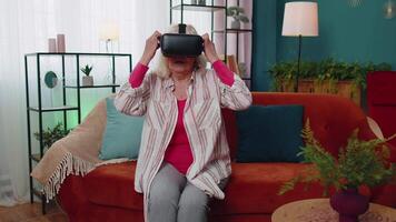 Senior woman using virtual reality VR app headset helmet to play simulation 3D 360 video game online