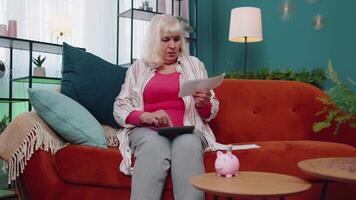 Senior mulher contando dinheiro a partir de cofrinho e calculando Forma de pagamento doméstico financeiro despesas contas video