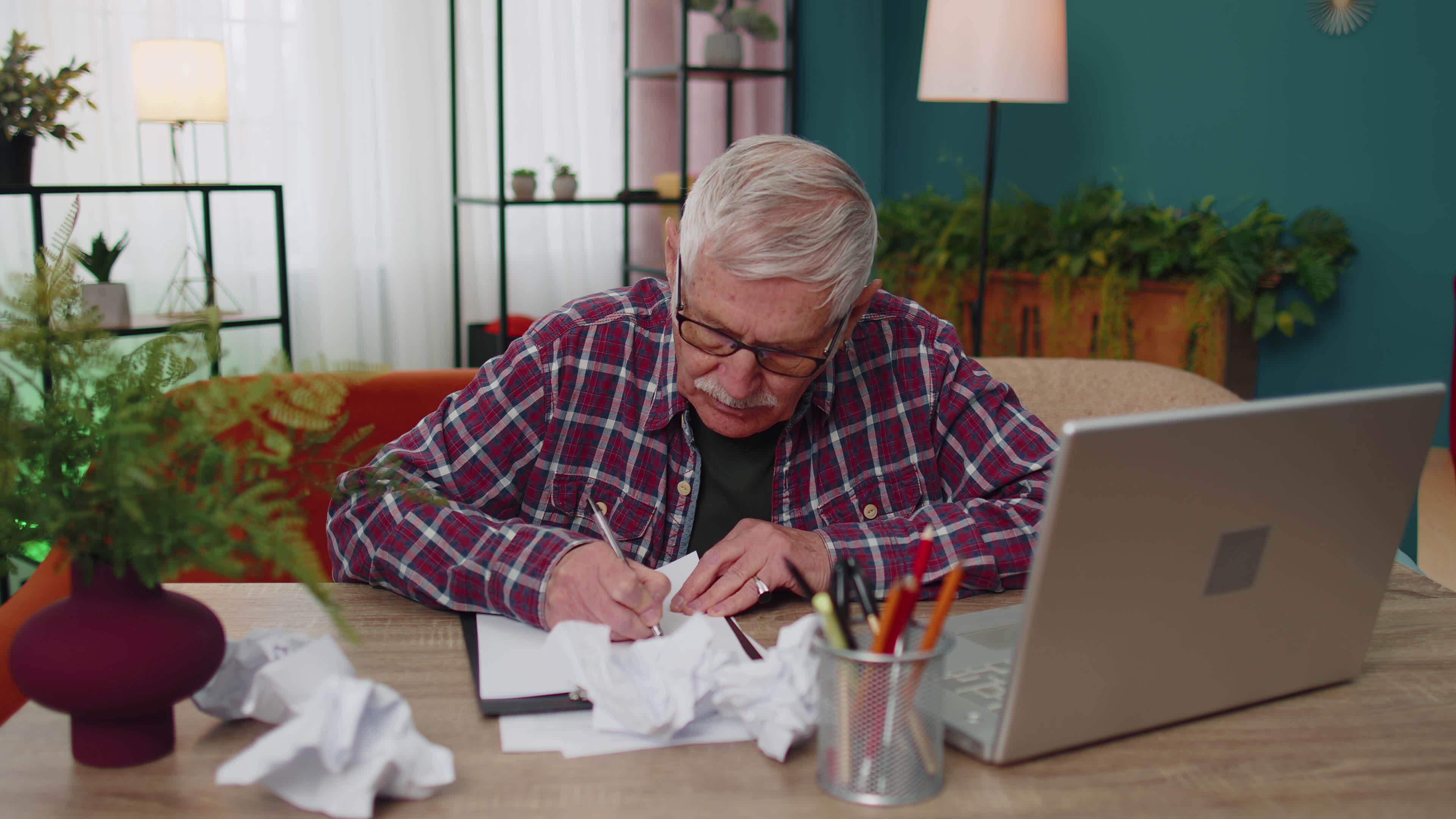 Grandfather working on laptop man writing on paper sheet, getting angry