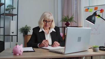 Sénior affaires femme en cours d'analyse formalités administratives les documents sous le choc par soudain gagner la victoire, bien nouvelles, sensationnel video