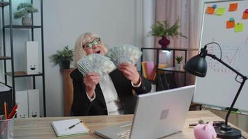 o negócio mulher contador a comemorar o negócio sucesso dançando com pilha do dinheiro dólar dinheiro video