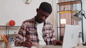 Young man guy using laptop computer sitting at table working, online shopping from home office video