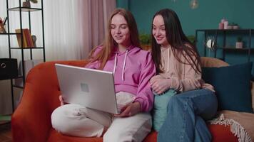 Young teen girls friends siblings smiling making online video call communication on laptop notebook