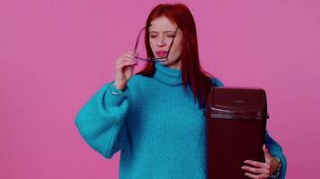 Happy redhead teen girl in blue sweater taking off, throwing out glasses after vision treatment video