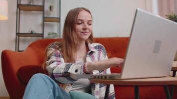 joven mujer niña utilizando ordenador portátil computadora sentado en piso laboral, en línea compras desde hogar oficina video