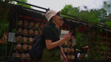 arrière vue de une couple portant Chapeaux à la recherche à une rue marché entouré par verdure. video