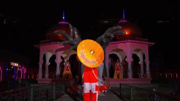 traditionnel Indien danseurs performant à nuit avec vibrant costumes et illuminé toile de fond. video