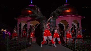 Traditional dance performance at night with illuminated architectural backdrop. video