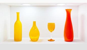 Orange glassware set Displayed in a white shelf photo