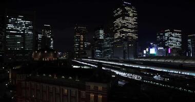 en natt panorama- stadsbild i främre av tokyo station bred skott video