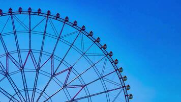 een timelapse van ferris wiel Bij de park achter de blauw lucht telefoto schot kantelen video