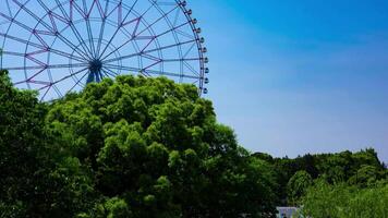 ein Zeitraffer von ziehen um Ferris Rad beim das Park hinter das Blau Himmel Schwenken video