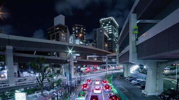 A night timelapse of the traffic jam at the urban street in Tokyo wide shot panning video