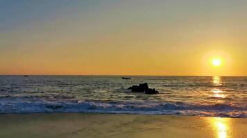 vistoso dorado puesta de sol grande olas rocas playa puerto escondido México. video