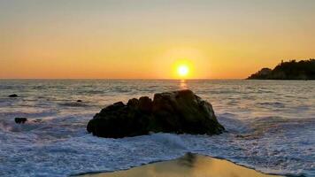 coloré d'or le coucher du soleil gros vagues rochers plage puerto escondido Mexique. video