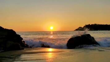 vistoso dorado puesta de sol grande olas rocas playa puerto escondido México. video
