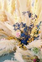 Colorful flowers surrounded by a cortaderia in a wedding arch photo