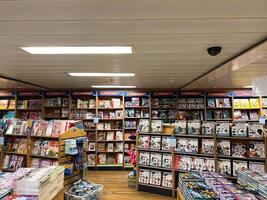 Herceg-Novi, Montenegro - 17 august 2023. Books in colorful covers stand on the shelves of cabinets in a bookstore photo