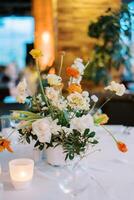 Bright bouquet of flowers in a vase stands on a set table photo