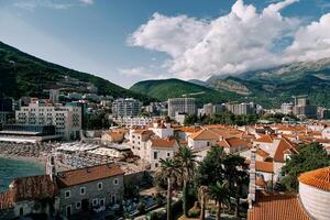 View over the red roofs of old houses to the beach near the new high-rise buildings. Budva, Montenegro photo