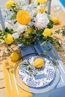 Lemon and olive branch lie on a plate next to a name card on a holiday table photo