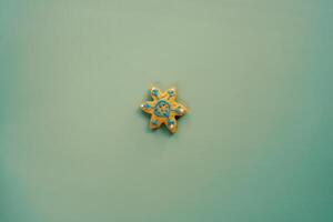 Glazed cookies in the shape of a snowflake lies on a green background photo