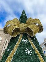 Artificial Christmas tree decorated with a huge fluffy bow photo