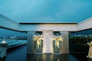 Illuminated stand with bouquets of flowers on the terrace near the tables. Caption. Love photo