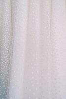Hem of a white tulle wedding dress with glitter photo