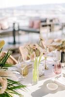 Bouquet of flowers stands on a served table among glasses photo