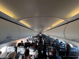 Afines, Greece - 20 august 2023. Rows of seats with passengers in the cabin of a passenger aircraft photo