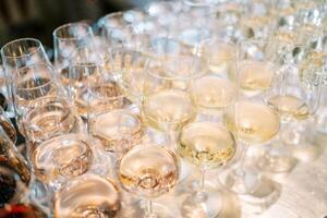 Rows of glasses with champagne stand on the table photo