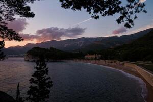 Beach near Villa Milocer at the foot of the mountains at sunset. Montenegro photo