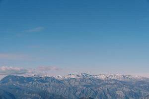 Snow-covered mountain range above the Bay of Kotor against the blue sky in winter. Montenegro photo