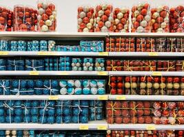 Podgorica, Montenegro - 25 december 2022. Sets of balls in transparent boxes on the shelves in the supermarket photo