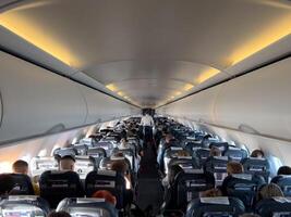 Afines, Greece - 20 august 2023. Passengers sit on chairs in the plane cabin. Back view photo