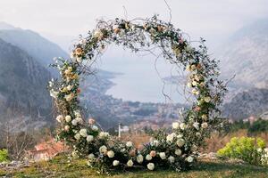 Round wedding arch stands on a mountain on the Bay of Kotor in the valley photo
