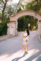 Mother with a little girl in her arms walks along the road in the park photo