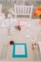 Bright personalized invitation lies on the festive table next to a bouquet of flowers photo