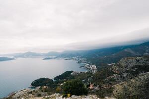 Bay surrounded by high green mountains in fog photo