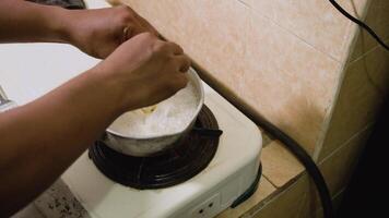 Process of cooking boiled noodles. Noodles that are being boiled in hot water using a stove. 4K video recording.